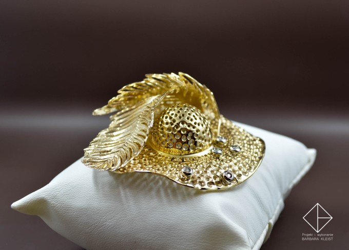 Złoty kapelusz z brylantami pod piórami